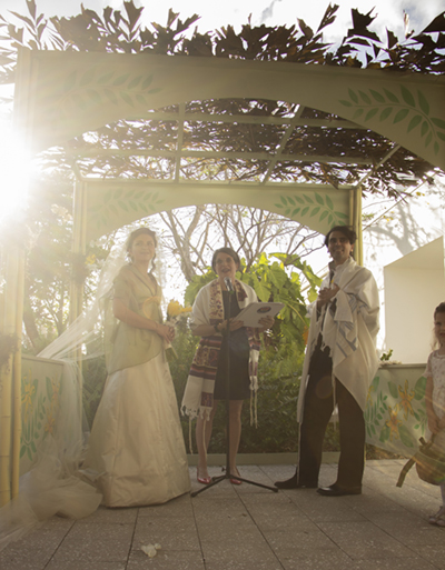 Elizabeth officiating a wedding under a chuppah